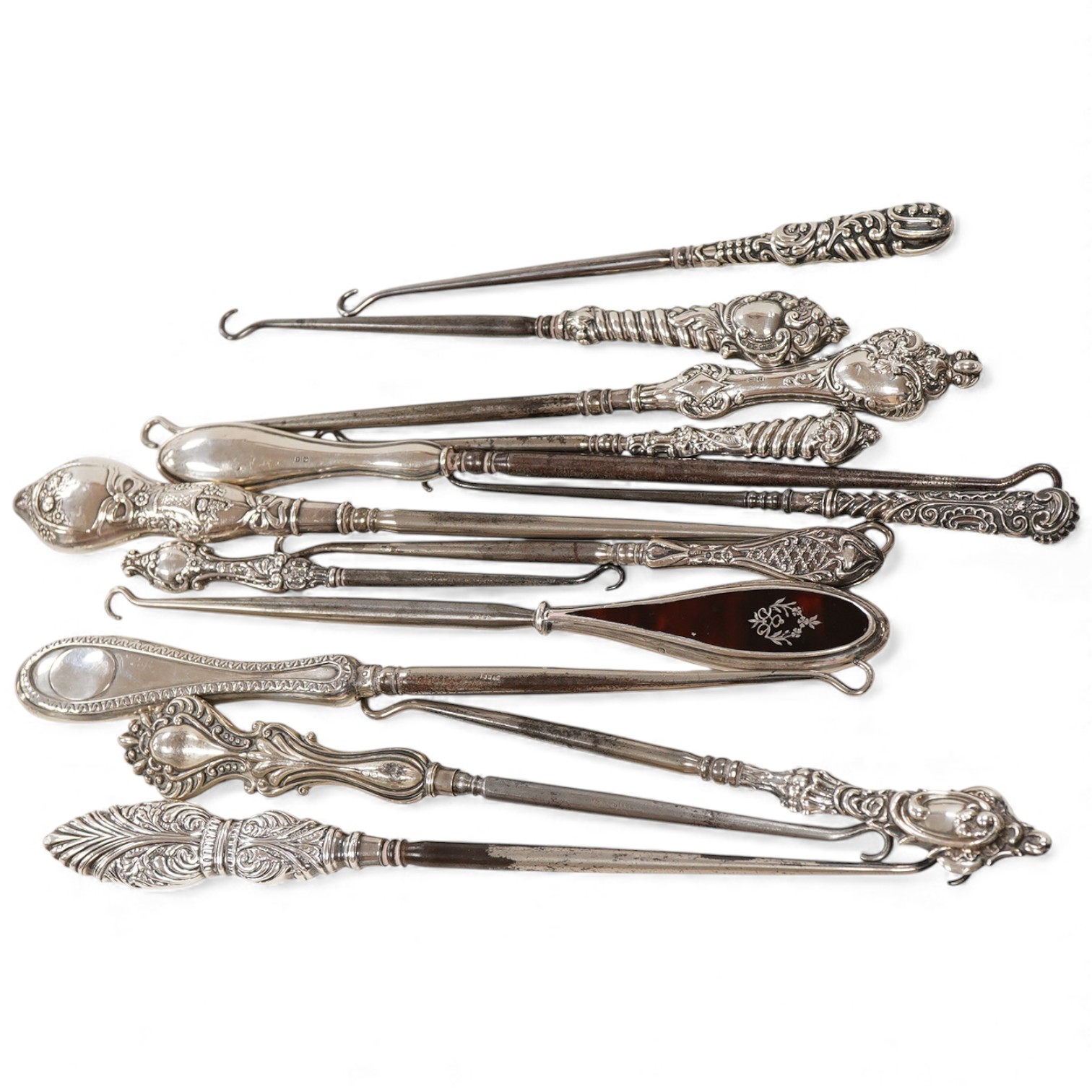 A collection of fourteen assorted late 19th/early 20th century silver handled button hooks, including tortoiseshell pique, longest 24.4cm.